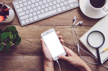 Akıllı telefon, çalışma masası ile laptop, kafa tutan üstten görünüm el