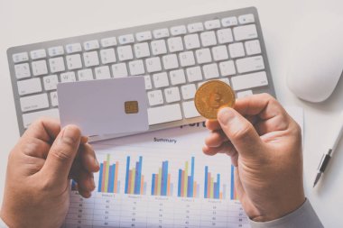 Kredi kartı ile bir dizüstü bilgisayar arka plan ile bitcoins tutan el 
