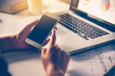 akıllı telefon ve açık alan görevliler içinde laptop üzerinde işadamı