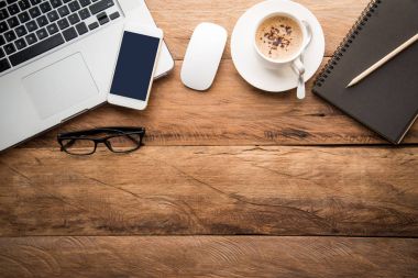 Üstten Görünüm ile kopya alanı, dizüstü bilgisayar, cep telefonu, defter kalem ve kahve ofis çalışma masası. 