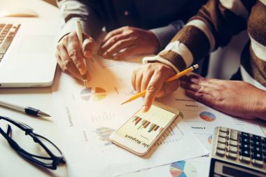 İş ekibi dizüstü bilgisayar ve akıllı telefon açık alan ofiste çalışıyor. Toplantı rapor devam ediyor. Güneş parlama efekti 