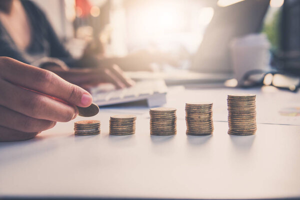 Hand putting money coin on each line rising team businessmen background - business saving money concept. 