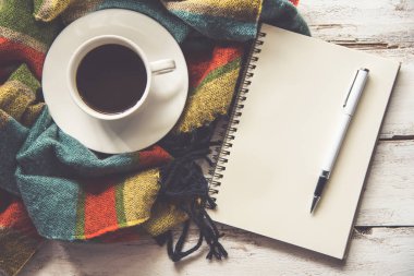 Kahve fincanı ve eşarp kalemi beyaz bir ahşap zemin yerleştirilir.