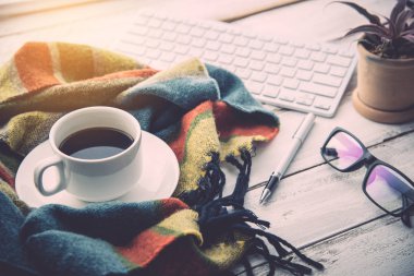 Kahve fincanı ve eşarp bir beyaz ahşap zemin yerleştirilir.