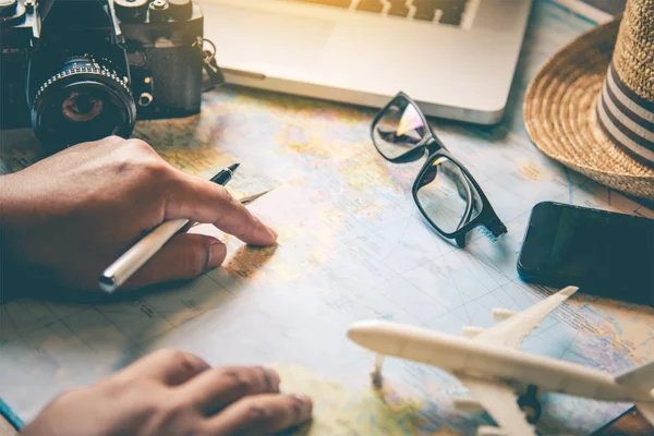 Reisende planen eine Reise, indem sie die Route auf der Karte suchen und im Internet nach Informationen suchen.. — Stockfoto