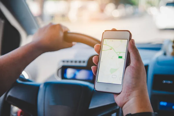 Motorista sentado no carro e segurando telefone inteligente móvel com — Fotografia de Stock