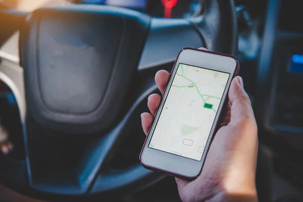 Motorista sentado no carro e segurando telefone inteligente móvel com — Fotografia de Stock