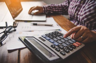 İş adamı bir hesap makinesi ve belge ile çalışıyor. Toplantı 