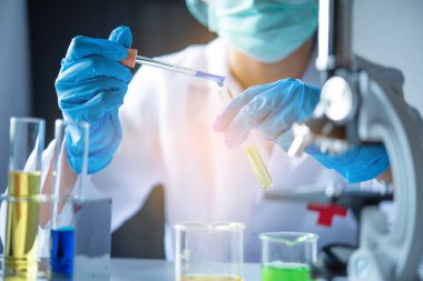 Yakın çekim pipeti bir uzmanlık alanında bir numuneyi test tüpüne atıyor.