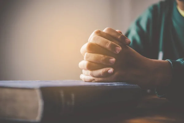 在祷告基督教的时候，手上的女人躺在圣经上 — 图库照片