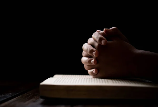 Hıristiyanlık için dua ederken İncil 'in üzerine uzanan eller.