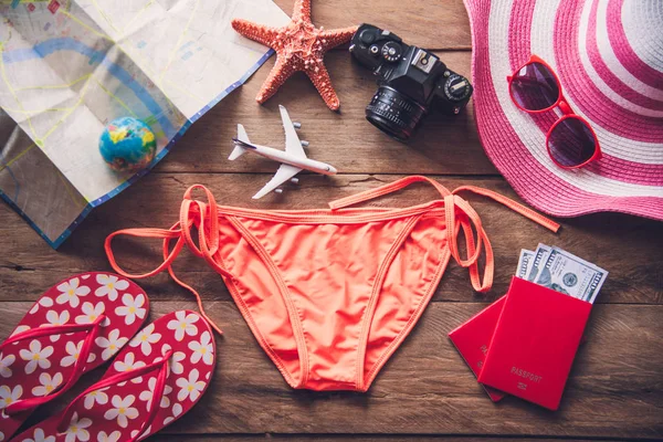 Bikini e accessori di bellezza arancione sul pavimento in legno per il viaggio — Foto Stock