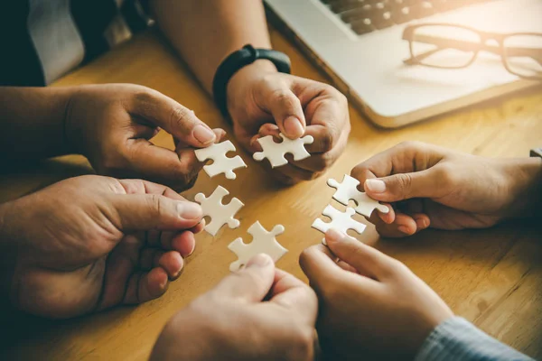 Business team gestire un pezzo di puzzle bianchi che stanno per — Foto Stock