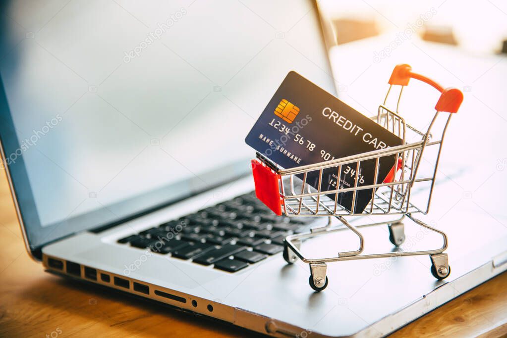 Small shopping cart with credit card on laptop, online shopping 