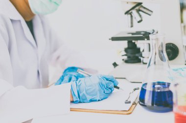  Bilim adamı bir notaya bilimsel değeri kaydediyor. LAP odasında yapılan bir deneyde.