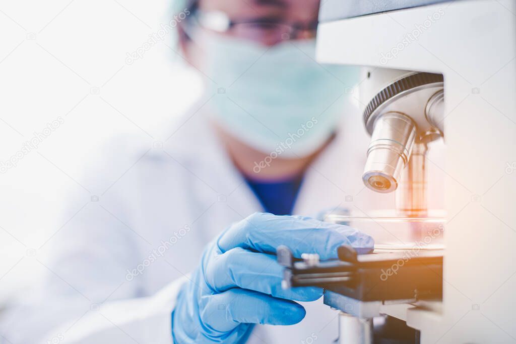 female medical researcher looking at a microscope in a medical laboratory. Medical experimental concept