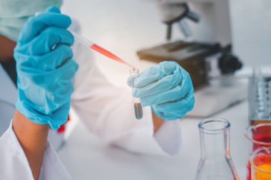  Kadın araştırmacılar, laboratuvar araştırmalarında bir deney tüpünün içine bir örnek bırakarak deney yapıyorlar..