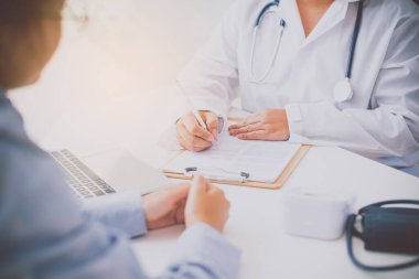 Doktor, sonuçlar ve tedavinin fiziksel muayenesinden sonra hastayla tartışıyor. 