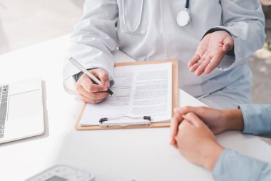 Doktor, sonuçlar ve tedavinin fiziksel muayenesinden sonra hastayla tartışıyor. 