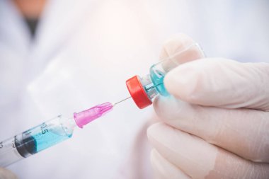 Şırıngalı doktor hastaya aşı yapmaya hazır. Aşılama kavramı.