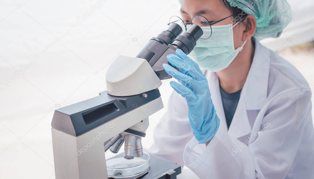 female medical researcher looking at a microscope in a medical laboratory. Medical experimental concept