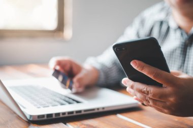 Kredi kartları ve cep telefonu tutan kadın şimdi internet üzerinden kredi kartı ile ödeyerek alışveriş vardır.