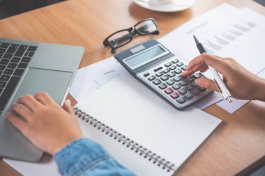 Muhasebecinin eli hesap makinesini kullanıyor. Maliyet analizi için kar ve zarar ve vergi hesaplama konsepti finansal açıklamaların hazırlanması