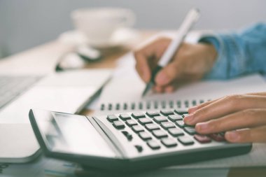 Muhasebecinin eli hesap makinesini kullanıyor. Maliyet analizi için kar ve zarar ve vergi hesaplama konsepti finansal açıklamaların hazırlanması
