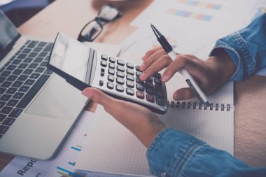 Muhasebecinin eli hesap makinesini kullanıyor. Maliyet analizi için kar ve zarar ve vergi hesaplama konsepti finansal açıklamaların hazırlanması