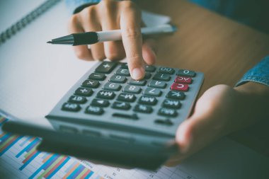 Muhasebecinin eli hesap makinesini kullanıyor. Maliyet analizi için kar ve zarar ve vergi hesaplama konsepti finansal açıklamaların hazırlanması