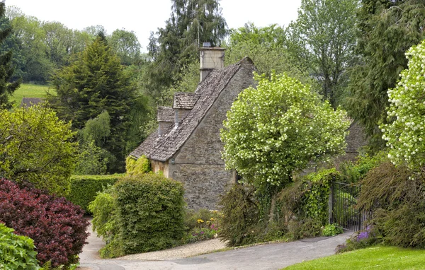 Velha casa escondida em árvores e jardins Imagens Royalty-Free