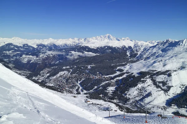 Village de station de ski dans une vallée avec de hautes montagnes en toile de fond — Photo