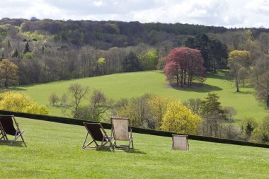 Spring country landscape viewed from deckchairs clipart