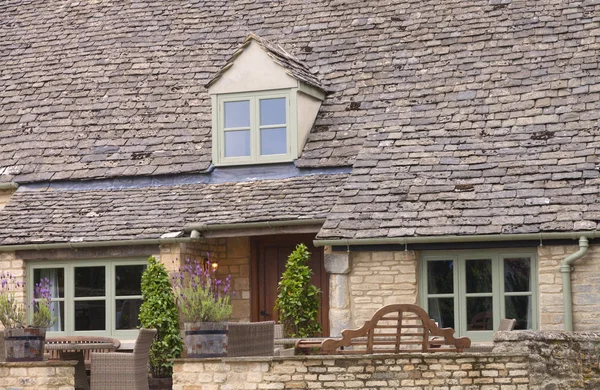 Old house with slate roof and patio with garden furniture — Stock Photo, Image