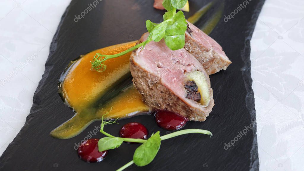 Gourmet succulent pork meat cuts with fruity sauces served on a stone plate