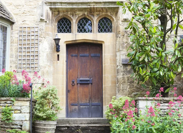 Old front doors in a stone historic house, with plants around it . — Stock Photo, Image