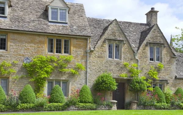 English stone cottages with topiary plants and flowers in front garden — Stock Photo, Image