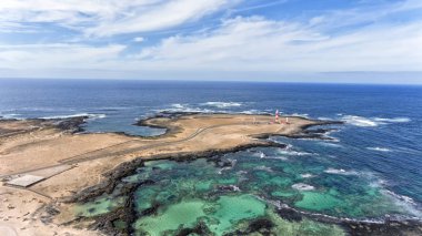Aerial view of lighthouse, turquoise lagoons, sandy beaches, rocky shore in El Cotillo, Fuerteventura, Canary Islands, Spain. clipart