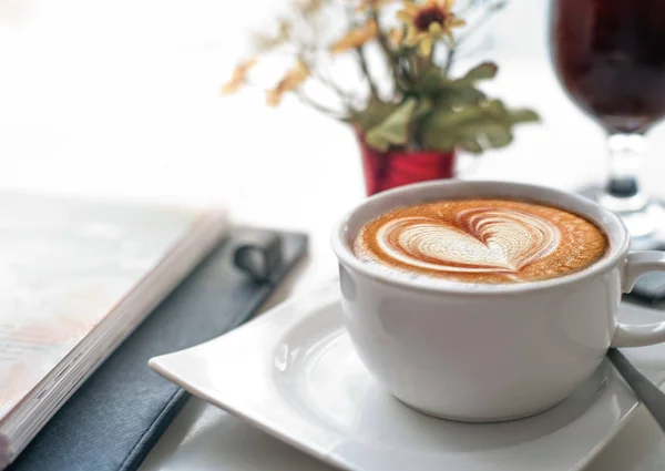 Çalışma Masası iş toplantısı sırasında kahve. Bir fincan kahve aşk kalp şekli latte sanat ve günlük ya da ajanda notu ile. Kahve Saati sonu.