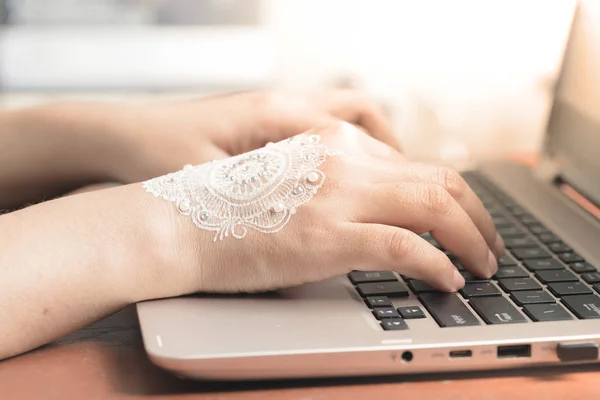 Kadın el laptop klavyede yazarak kına ile. İş kavramı ya da kadın çalışma ofisten sonra düğün kutlama