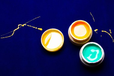 mavi arka plan üzerinde bir manikür için parlak renkler. dökülen sarı boya. yarım yamalak 