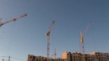 bir bölgeye Vinçler mavi gökyüzü arka plan üzerinde Sibirya kentinde inşaatı. taymlaps