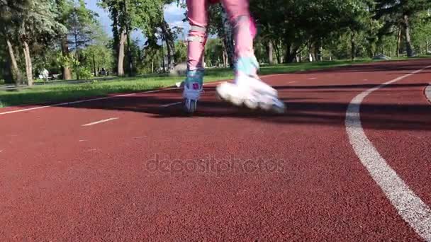 En flicka i Rosa kläder skridskor i en roller-skating park på kvällen — Stockvideo