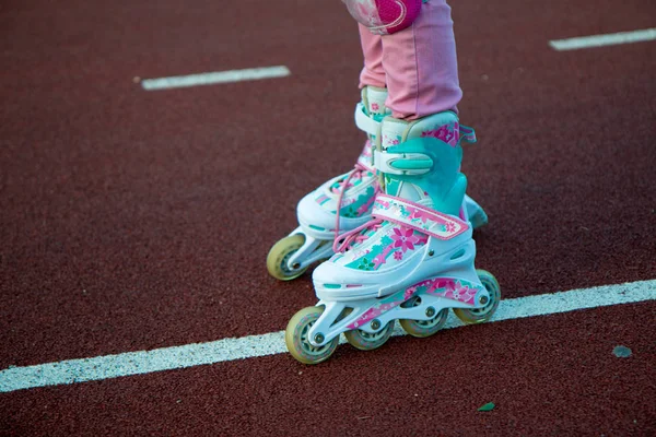 Un fragment de jambes d'enfants en patins à roulettes sur une piste cyclable — Photo