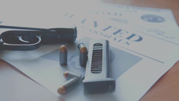 Eine Ankündigung über die Suche nach einem Verbrecher auf dem Tisch des Kopfgeldjägers, eine Kampfpistole, Patronen — Stockvideo