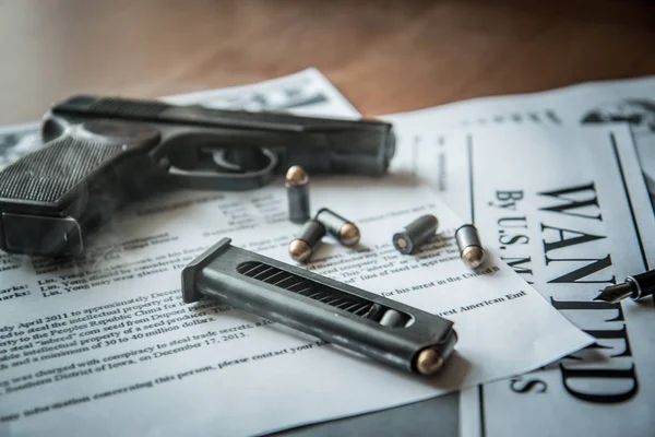 An announcement about the search for a criminal on the table of the bounty hunter, a combat pistol, cartridges — Stock Photo, Image