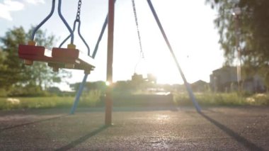 Bir salıncak ile zincir yalnız kalan boş bir parkta günbatımında insanlar olmadan. Yalnızlık duygusu