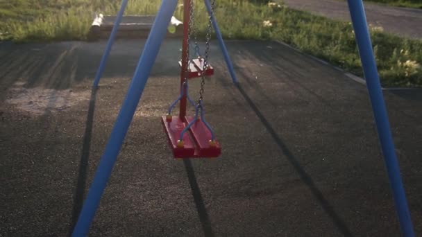 夕暮れ空の公園で一人で長引く人なしチェーン スイング。孤独感 — ストック動画