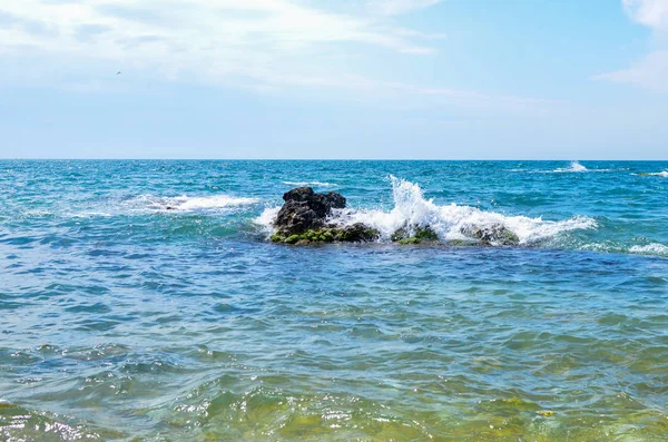 Küstenwellen des Schwarzen Meeres stoßen gegen einen aus dem Wasser ragenden Stein. Krim 2017 — Stockfoto