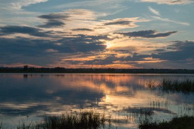 Bir rüzgar olmadan bir su birikintisi üzerinde çekici güzel günbatımı